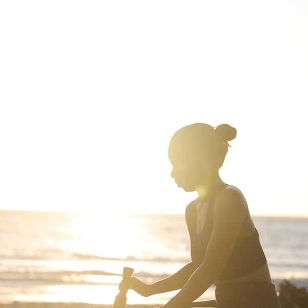 Silhouette of a person meditating at sunrise, symbolizing energy and well-being.