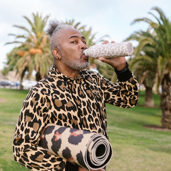 Yoga mat rolled out next to a water bottle and a small plant, ready for practice.